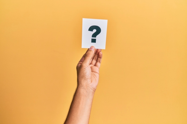 question mark on a small paper held by a man's hand depicting FAQs about Heating Efficiency