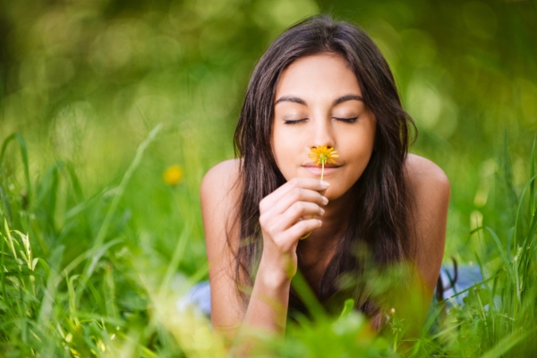 woman smelling a flower depicting propane has no natural smell