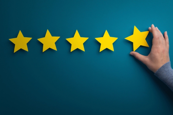 hand of a woman sticking a cutout star for customer review depicting 8. Established Reputation in HVAC Services