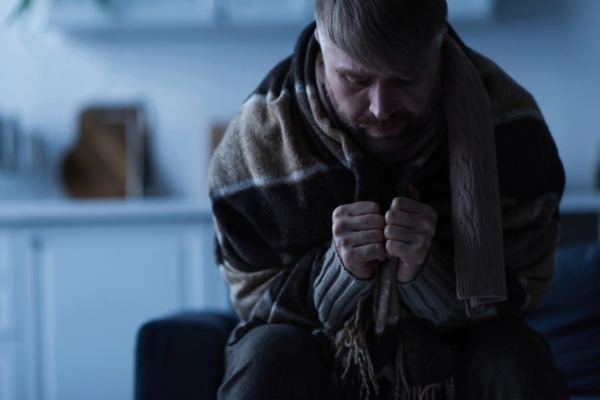 man feeling cold indoors depicting winter emergency due to propane shortage